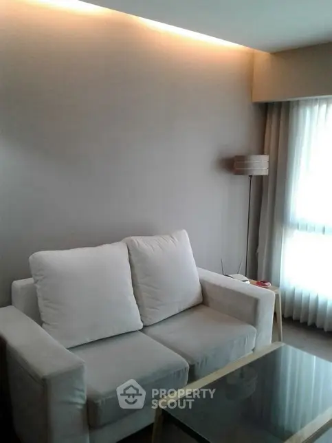 Cozy living room with modern sofa and floor lamp, ideal for relaxation.