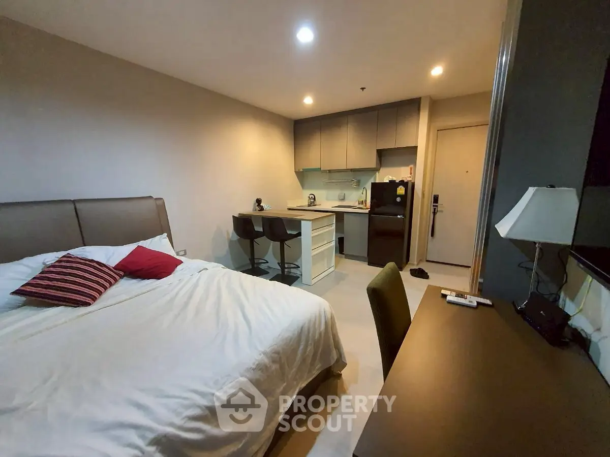 Modern studio apartment with cozy bedroom and compact kitchen