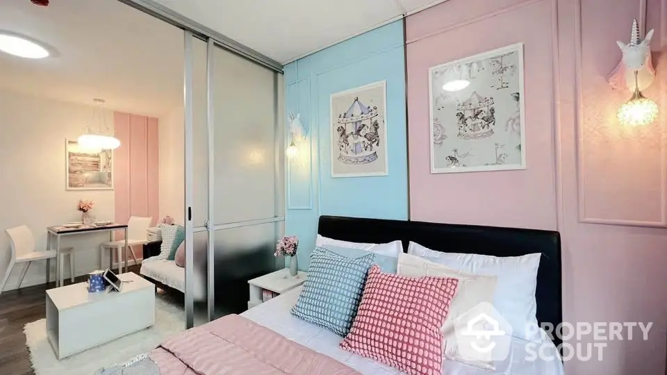 Charming bedroom with pastel decor and sliding doors leading to a cozy dining area.