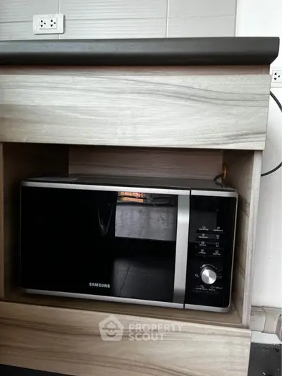 Modern kitchen with built-in Samsung microwave in stylish wooden cabinetry.