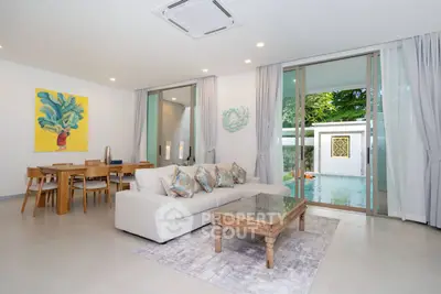 Luxurious living room with pool view, elegant decor, and modern furnishings in a serene setting.