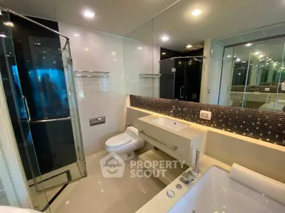 Luxurious modern bathroom with glass shower and bathtub in elegant apartment.