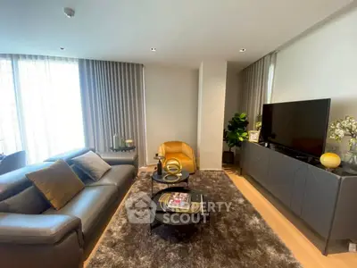 Modern living room with sleek furniture and large windows for natural light.