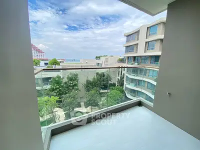 Spacious balcony with stunning view of modern buildings and lush greenery.