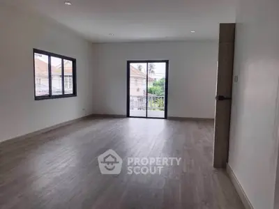 Spacious empty room with large windows and balcony access, perfect for customization.