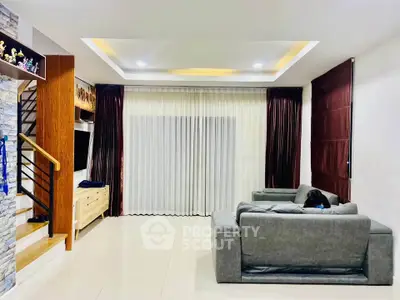 Spacious living room with modern decor and cozy seating area, perfect for relaxation and entertainment.
