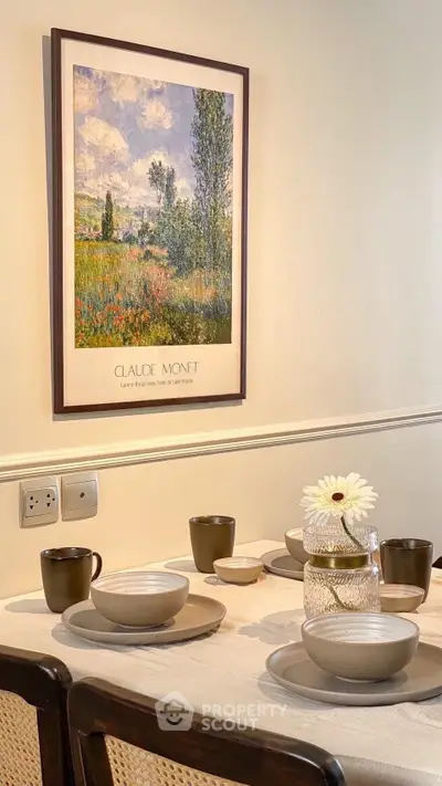 Charming dining area with elegant table setting and Monet artwork, perfect for cozy gatherings.