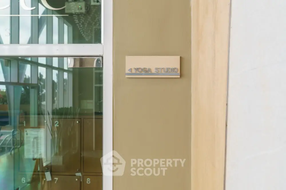 Modern yoga studio entrance with glass door and lockers