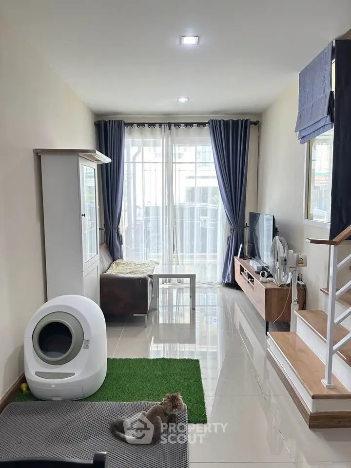 Charming living room with modern decor and natural light, featuring cozy seating and stylish entertainment center.