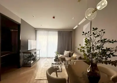 Modern living room with elegant decor, large TV, and stylish lighting in a cozy apartment.