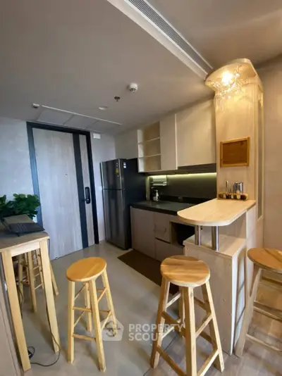 Modern kitchen with sleek design, featuring a breakfast bar and stainless steel appliances.