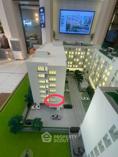 Modern architectural model showcasing urban residential complex with green spaces and parking.