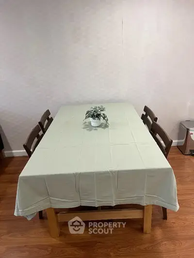 Spacious dining area with elegant table setting and wooden chairs, perfect for family gatherings.