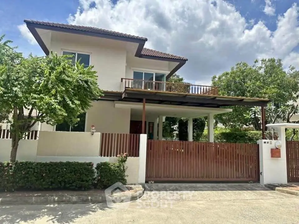 Charming two-story house with spacious balcony and lush greenery, perfect for family living.