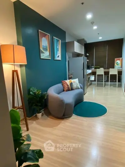 Modern living room with stylish decor and open kitchen layout, featuring cozy seating and vibrant accents.