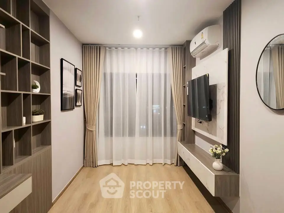 Modern living room with stylish decor and wall-mounted TV, featuring elegant curtains and wooden flooring.