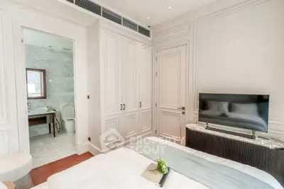 Luxurious bedroom with ensuite bathroom and modern TV setup