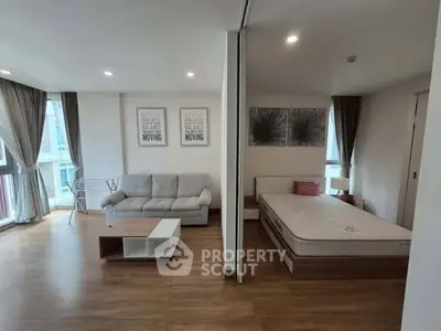 Modern open-plan living room and bedroom with stylish decor and natural light.