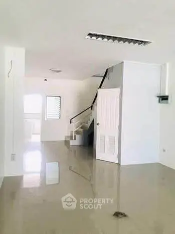 Spacious open-plan interior with glossy floors and staircase, ideal for modern living.