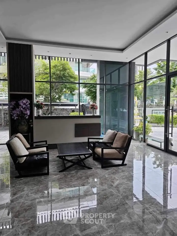 Elegant modern lobby with floor-to-ceiling windows and stylish seating area.