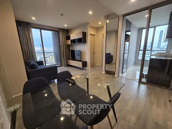 Modern open-plan living room with city view and sleek glass dining table.