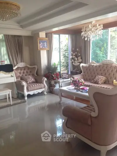 Elegant living room with plush seating and chandelier, perfect for luxury living.