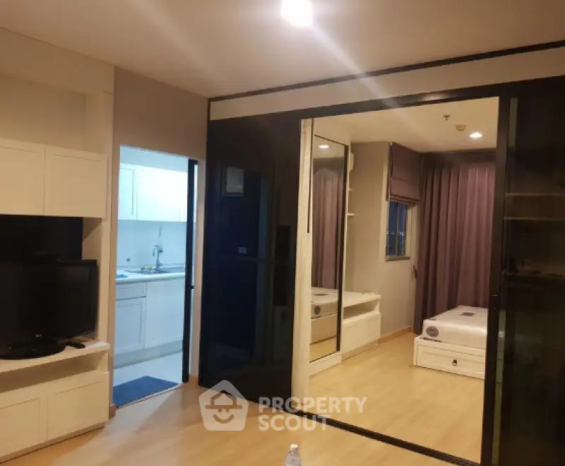 Modern apartment interior with open layout, featuring a cozy living room and adjacent bedroom.
