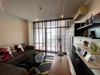 Modern living room with stylish decor and balcony view, featuring sleek furniture and ample natural light.