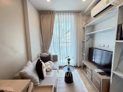 Modern living room with stylish decor, large window, and cozy seating area in a contemporary apartment.