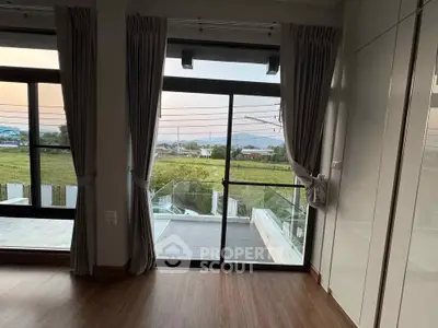 Spacious room with large windows offering stunning countryside views, perfect for serene living.