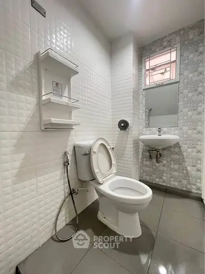 Modern bathroom with sleek white tiles and contemporary fixtures.