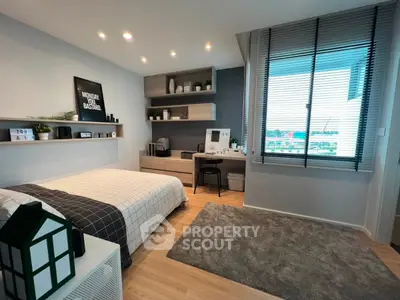 Modern bedroom with stylish decor and large window offering natural light.