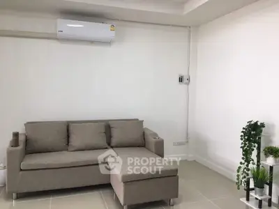 Modern living room with beige sofa and air conditioning, perfect for relaxation and comfort.