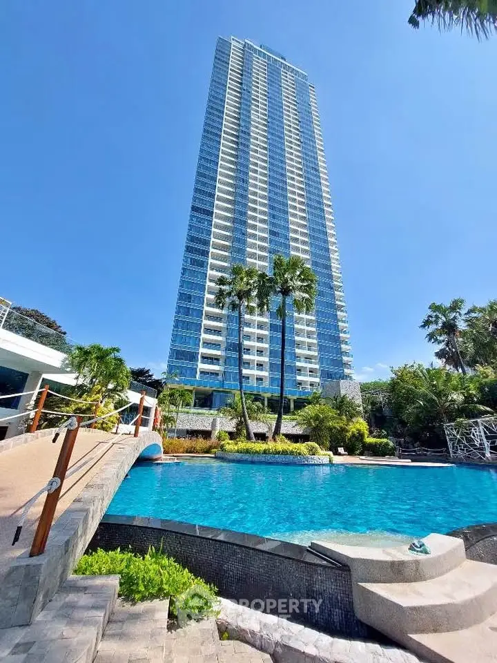 Luxurious high-rise building with stunning pool and lush landscaping, perfect for upscale living.