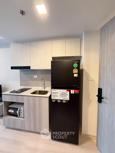 Modern kitchen with sleek cabinetry and appliances in a stylish apartment.