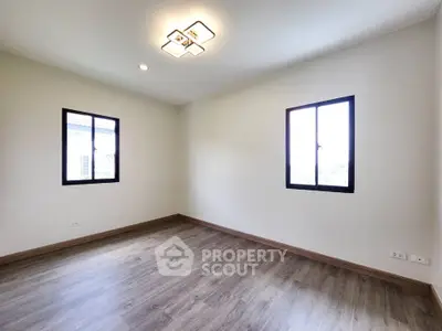 Spacious empty room with modern lighting and large windows, perfect for customization.