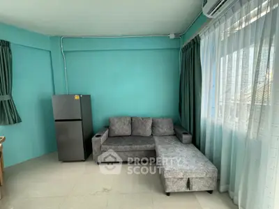 Cozy living room with modern gray sofa and large window, perfect for relaxation.