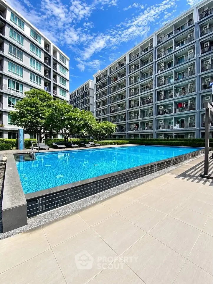 Modern apartment complex with a stunning outdoor pool and lush greenery.