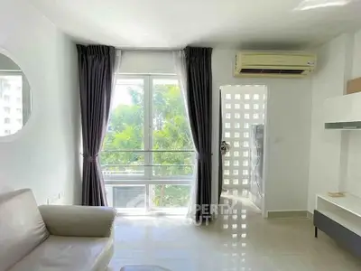 Bright living room with large window and air conditioning, featuring modern decor and a serene view.