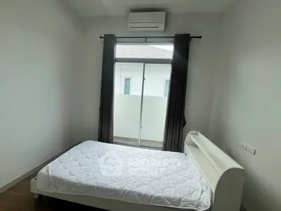 Cozy bedroom with air conditioning and balcony access in modern home.