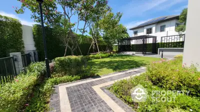 Beautiful garden with lush greenery and modern house in the background, perfect for relaxation.