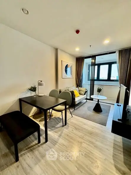 Modern living room with stylish decor and large windows offering natural light.