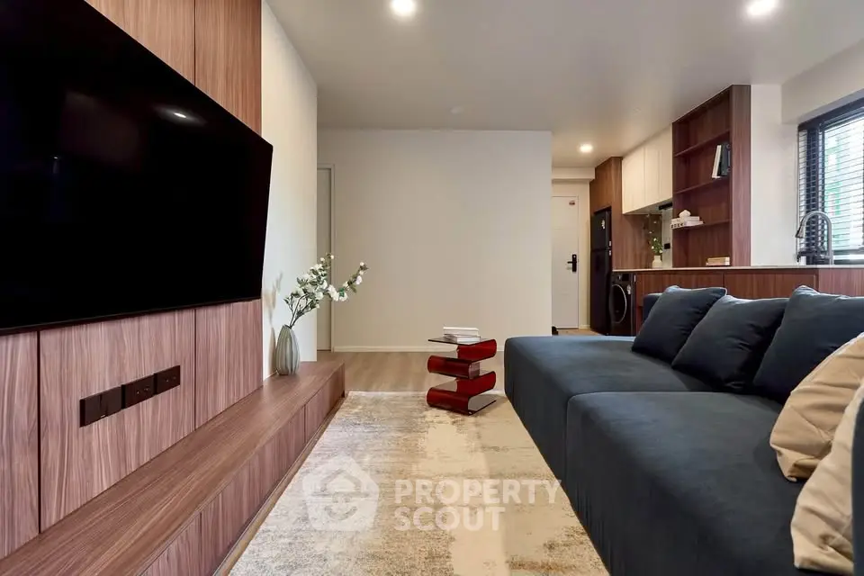 Modern living room with sleek wooden paneling and large TV