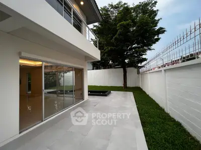 Modern home exterior with spacious patio and lush green garden