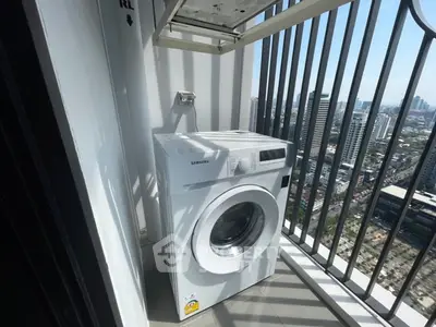 Modern balcony with washing machine and city view, perfect for urban living convenience.
