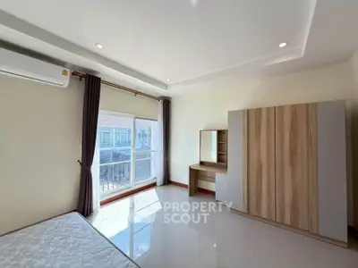 Spacious bedroom with large window and modern furniture