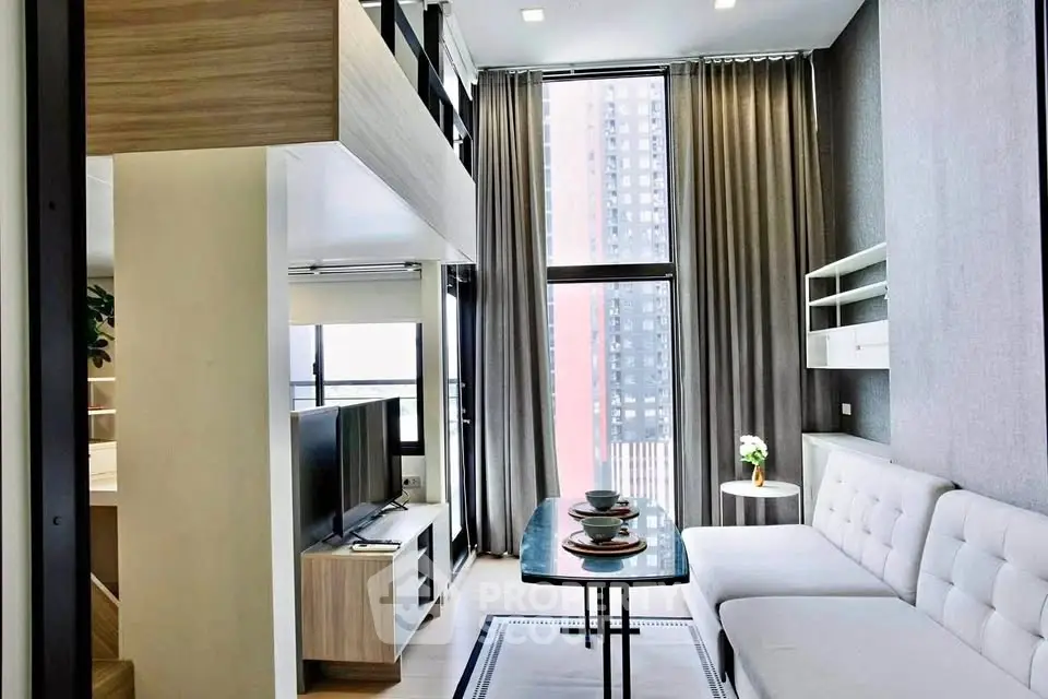 Modern living room with high ceilings and large windows in a stylish apartment.