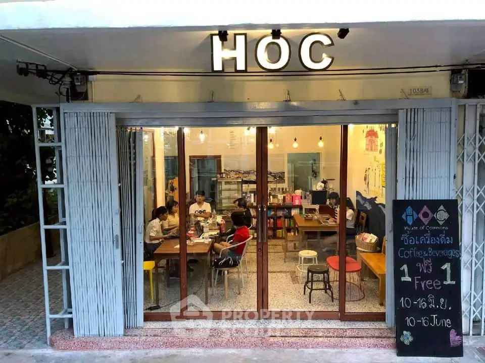 Charming cafe exterior with glass facade and inviting interior seating, perfect for social gatherings.