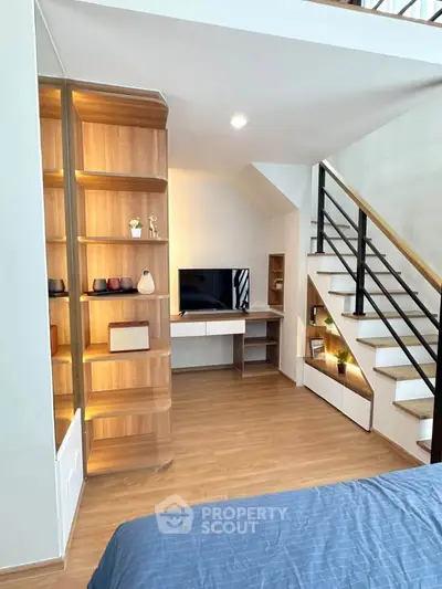 Modern living room with stylish wooden shelving and cozy staircase design
