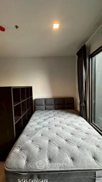 Cozy bedroom with modern decor and large window for natural light.